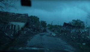 Разурнат дел од градот Покровск во Донецката област, со урнати згради, чад и остатоци од гранатирање; се гледаат украински војници во подготвени позиции.